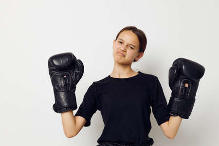 athletic woman in black sports uniform boxing gloves posing isolated backgroundの写真素材