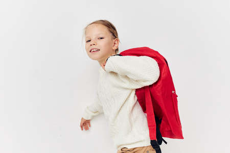 cute girl school backpack with a hat on his head light backgroundの写真素材