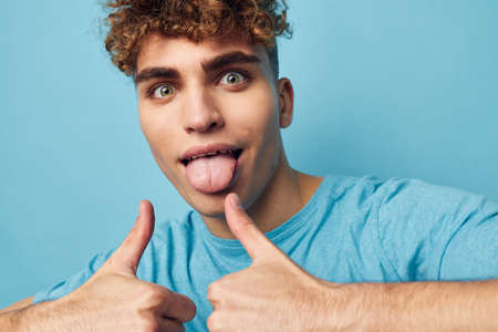 Attractive man in blue t-shirts with a pumped-up body blue backgroundの写真素材
