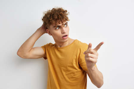 Attractive man in yellow t-shirts gesture hands emotions Lifestyle unalteredの写真素材