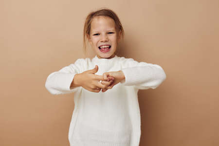 little girl in white sweater posing hand gestures Lifestyle unaltered