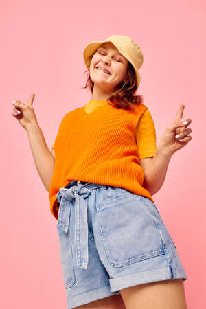beautiful woman orange sweater emotions fun pink background unaltered