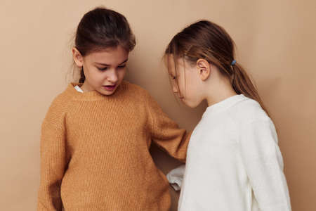 two cute little girls hug friendship lifestyle beige backgroundの写真素材