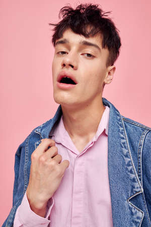 handsome guy fashion hairstyle posing clothing denim jacket modern style pink background unaltered
