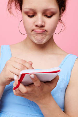 teenager girl learning with notebook and pen pink color background unalteredの写真素材