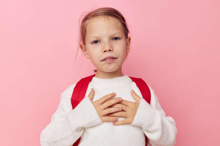 Portrait of happy smiling child girl with a red backpack fun isolated background