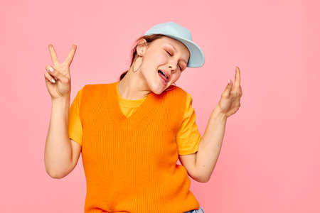 funny girl in an orange sweater in blue caps hand gesture Lifestyle unalteredの写真素材