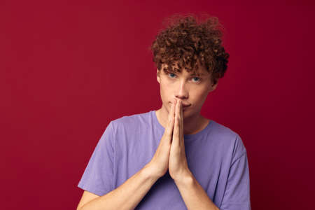 kinky guy in purple t-shirts posing emotions red background unaltered