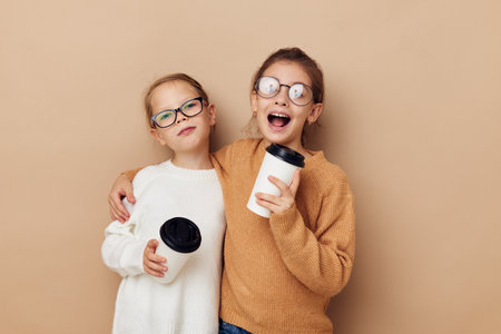 funny little girls with glasses with a drinkの写真素材