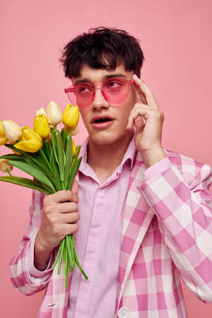portrait of a young man pink glasses checkered jacket fashion posing isolated background unalteredの写真素材