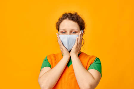 pretty girl in a yellow t-shirt medical mask protection cropped view unaltered