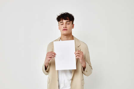 Man posing with a white sheet of paper light background unaltered