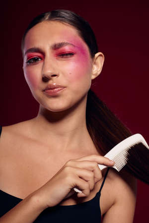 attractive woman with bright makeup combing her hair personal careの写真素材