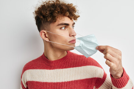 man in striped sweater medical mask health safetyの写真素材