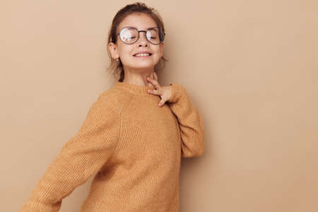 cute girl in a sweater and posing glasses isolated backgroundの写真素材