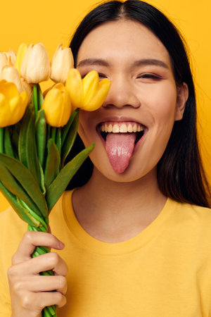 pretty brunette in a yellow t-shirt t-shirt with a bouquet of flowers holiday Monochrome shotの写真素材