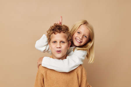 Little boy and girl in sweaters together fun childhood unalteredの写真素材