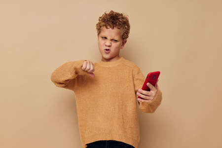 little boy with curly hair red phone technology fun