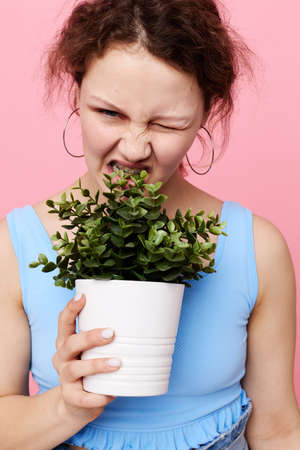 pretty girl potted flower posing plant isolated backgrounds unalteredの写真素材