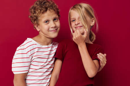 Boy and girl emotions stand side by side in everyday clothes on colored background unaltered