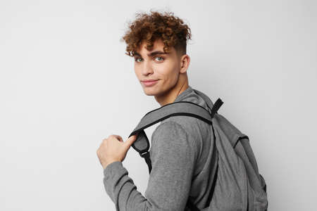 stylish guy in a gray sweater backpack fashion isolated background