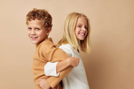 Portrait of cute children in sweaters together fun isolated backgroundの写真素材