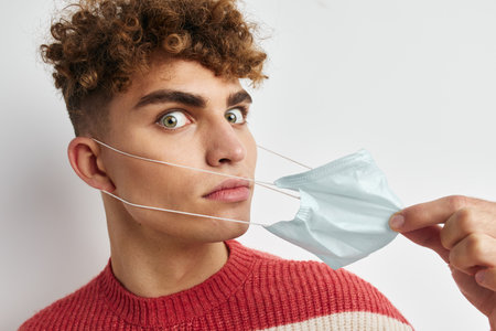 handsome man in striped sweater medical mask
