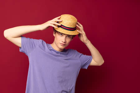 young guy fashion posing hand gestures stylish hat red background unalteredの写真素材