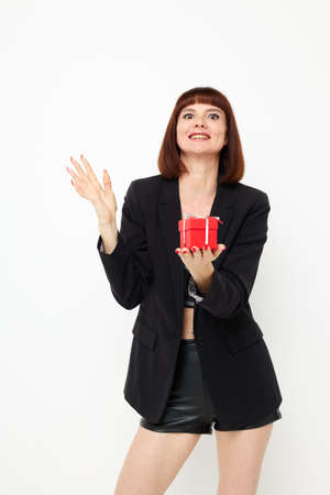 beautiful woman with gift small box in a leather suit black jacket isolated backgroundの写真素材