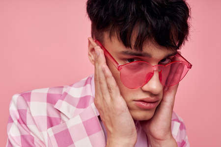 A young man in stylish clothes jacket fashion gestures with hands self-confidence model studio