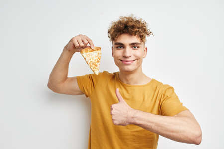 handsome young man eating pizza posing close-up Lifestyle unaltered