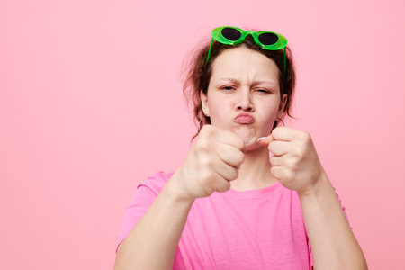 beautiful woman fashion green glasses pink t-shirt decoration posingの写真素材