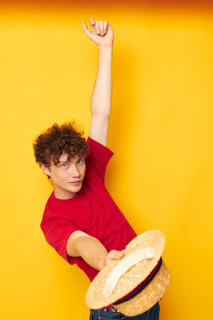 cute red-haired guy emotions red t-shirt hat studio yellow background unalteredの写真素材