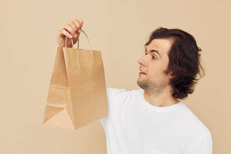 handsome man paper grocery bag posing isolated backgroundの写真素材