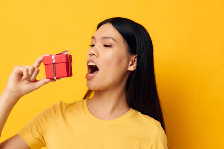 Portrait Asian beautiful young woman in a yellow t-shirt holiday gift emotions Lifestyle unalteredの写真素材