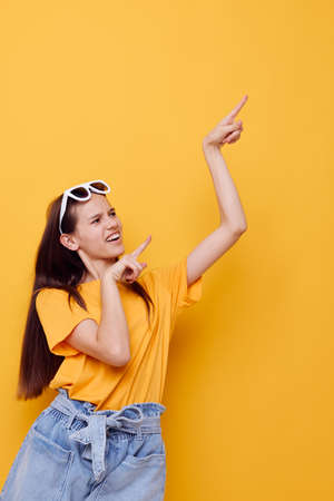young woman fashion in yellow t-shirt denim shorts yellow backgroundの写真素材