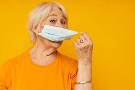 elderly woman happy lifestyle medical mask isolated backgroundの写真素材