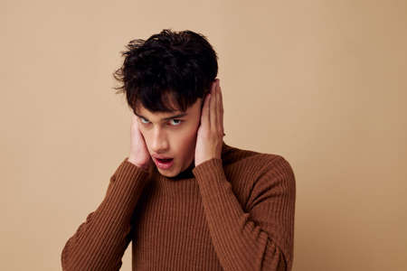 portrait of a young man stylish hairstyle brown turtleneck light background unaltered