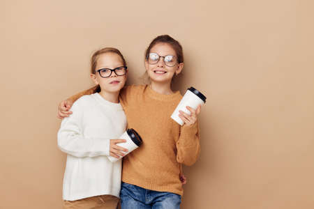 little girls hugging together glass with drinkの写真素材