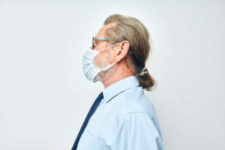 Portrait of happy senior man in shirt with tie medical mask safety light background