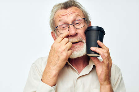 elderly man in a shirt and glasses a black glass light backgroundの写真素材