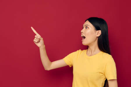 woman in a yellow t-shirt gesturing with his hands fun isolated background unalteredの写真素材
