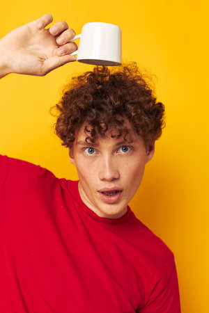 cute red-haired guy posing with a white mug and in the hands of a drink Lifestyle unalteredの写真素材