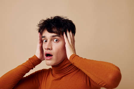 handsome guy brown turtleneck posing fashion light background unalteredの写真素材