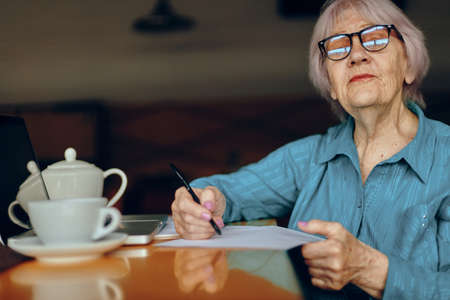 Portrait of an elderly woman documents work sheet of paper and pen unalteredの写真素材