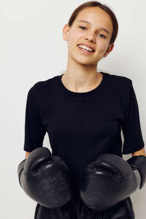 athletic woman in boxing gloves in black pants and a T-shirt isolated backgroundの写真素材