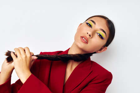 beautiful brunette bright makeup red jacket posing light background unalteredの写真素材