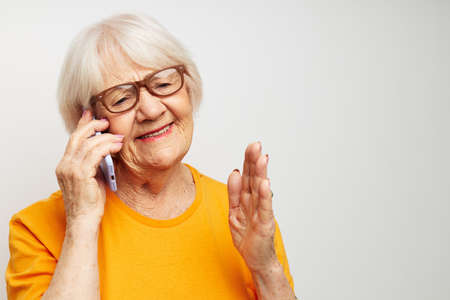 elderly woman happy lifestyle in yellow t-shirts close-up emotionsの写真素材