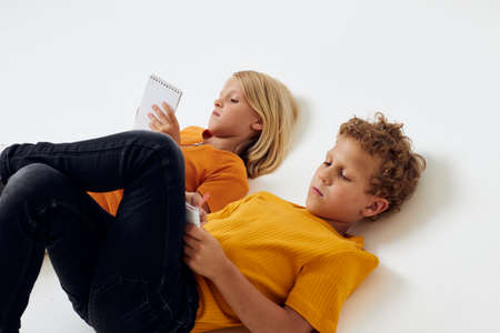 cheerful children lie on the floor with notepads and pencils childhood lifestyle unaltered