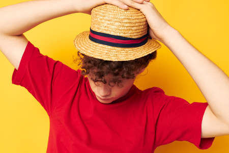 cute red-haired guy emotions red t-shirt hat studio yellow background unalteredの写真素材